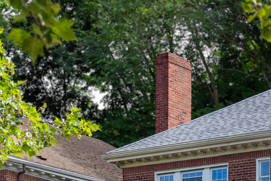 Red brick chimney and shingle roof with white dentil molding in Boston