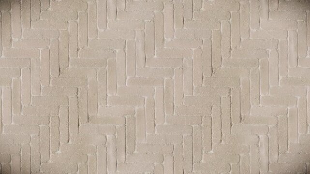Abstract beige herringbone paving texture forms a seamless loop background.
