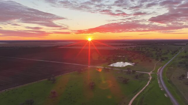 Aerial video flying over the Pilliga landscape at sunset in NSW, Australia. Warm golden light illuminates the expansive bushland and rural landscape
