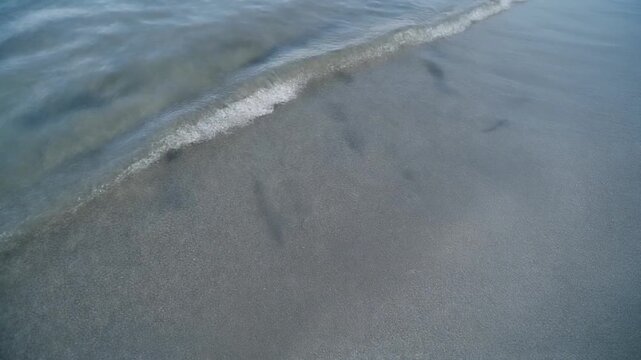 Minimalist shallow coastal water lapping over slate stone for website background, business presentation, and environmental science research.