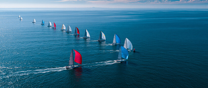 Thrilling Aerial View of Competitive Sailing Yachts in a Nautical Regatta on Blue Waters