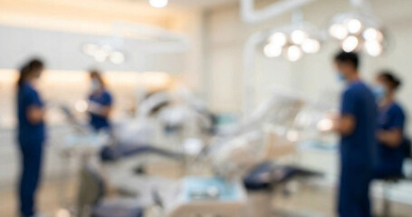 Obraz premium A blurred image depicting a dental clinic with dental professionals in blue scrubs working. The modern environment features dental equipment and bright lighting.