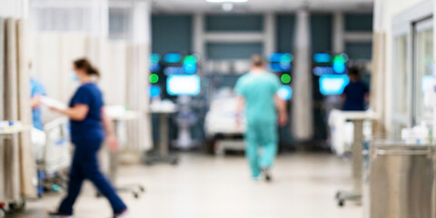 Fototapeta premium A busy hospital corridor with healthcare professionals attending to patients. Soft focus on medical equipment and staff, illustrating a dynamic healthcare environment.