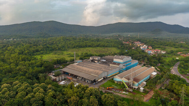 Rubber and tyre production facility surrounded by dense green forest and hills
