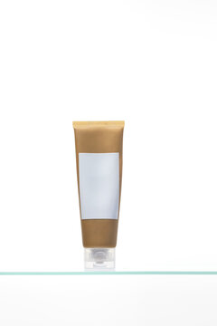 A luxurious cosmetic tube on a glass shelf. Ideal for body / hand lotion, face cream, or mask packaging mockups. Clean, minimalist design