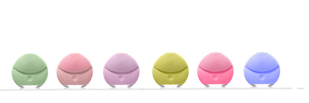 Banner of six colorful silicone facial cleansing devices in a row. Great for showing product variety, high-tech beauty tools, and modern skincare routines