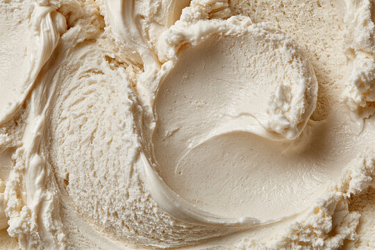 Creamy vanilla ice cream texture with smooth swirls and scoop marks