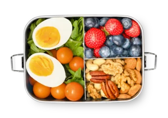 Lunch box with berries, nuts and salad on white isolated background, top view.Healthy eating and snacking concept. © Ирина Гутыряк