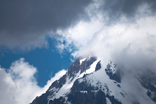 Majestic Mount Kazbek peak with storm clouds and blue sky in Georgia with copy space