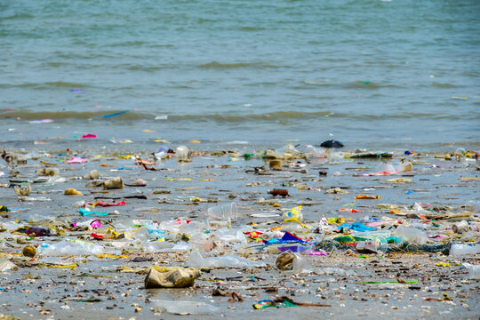 Polluted beach with plastic waste and garbage washed up on the shore, environmental pollution and ocean waste concept, ecological problem on tropical coast	

