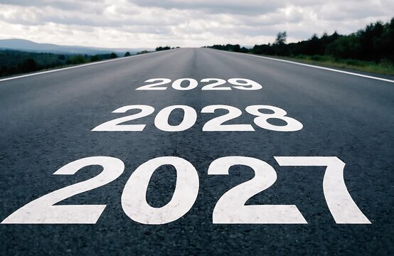 Future planning concept with years 2027 2028 and 2029 painted on an asphalt road surface planning milestones strategy