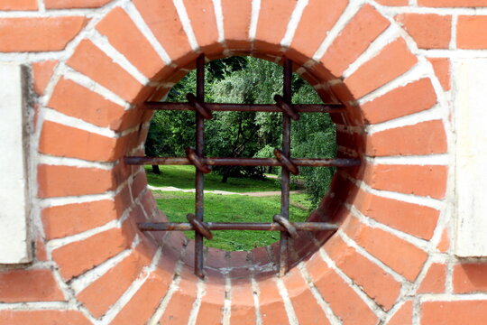 An unusual round window opening with iron bars.