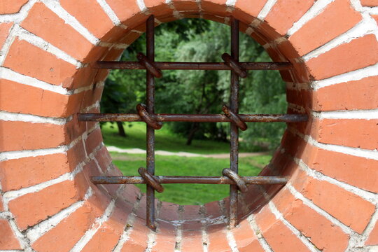 An unusual round window opening with iron bars.