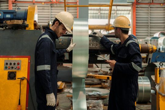 A team of engineers and staff are inspecting the production line system at a metal sheet and roofing factory. (PHOTO)	