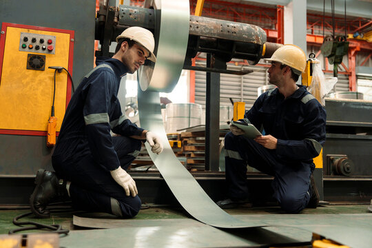 A team of engineers and staff are inspecting the production line system at a metal sheet and roofing factory. (PHOTO)	