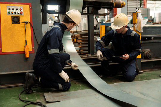 A team of engineers and staff are inspecting the production line system at a metal sheet and roofing factory. (PHOTO)	