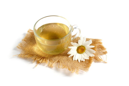 A cup of chamomile tea stands on a white background.