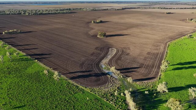 Aerial video flying over cultivated farmland at Pilliga, NSW, Australia. The cultivated soil creates striking natural patterns and textures