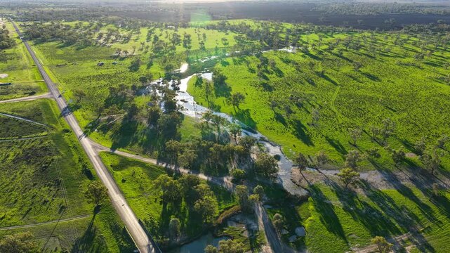 Aerial video flying over the Pilliga landscape at sunset in NSW, Australia. Warm golden light illuminates the expansive bushland and rural landscape