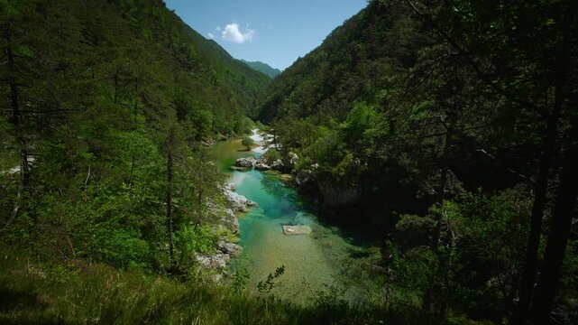 Deep natural rock basin filled with glowing emerald water inside a mountain canyon at Pozze Smeraldine.