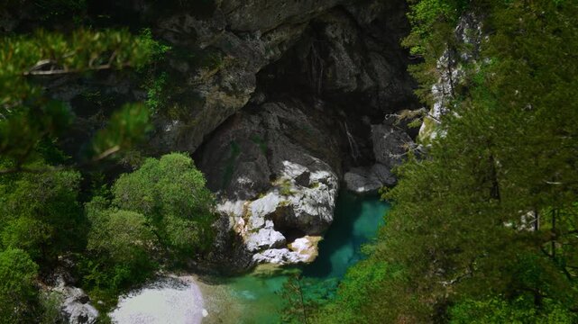Clear water cascade falling into a pristine turquoise mountain pool at Pozze Smeraldine in the Dolomites