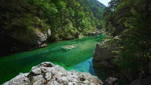 Crystal clear emerald water surface surrounded by massive white limestone boulders at Pozze Smeraldine