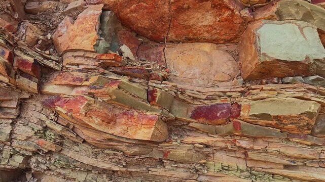 Close up reveals a folded sedimentary rock monocline where immense pressure and geothermal heat gradually bent layered strata into colorful weathered formations