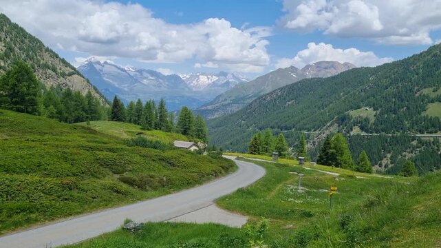 Stunning panoramic view from Simplon Pass overlooking the majestic Valais Alps on a bright summer day. Spectacular Swiss mountain landscape with pristine alpine peaks, endless vistas, natural paradise