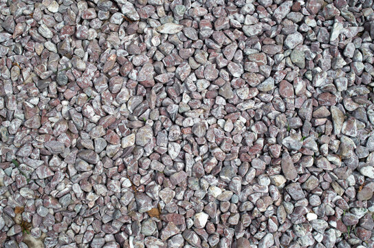 Background texture of small purple and white crushed round gravel stones closeup