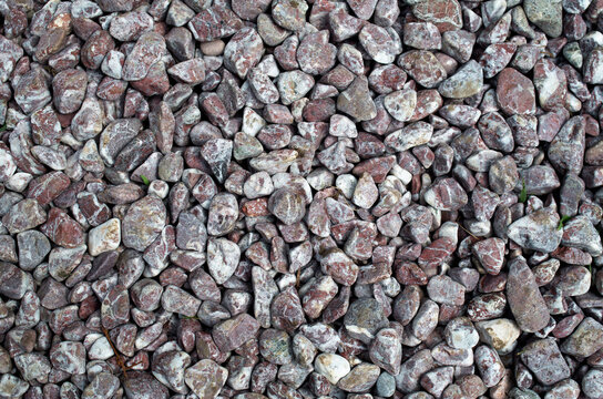 Background texture of small purple and white crushed round gravel stones closeup