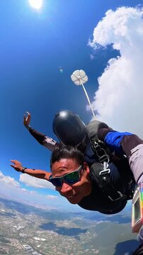 Tandem skydiver selfie during freefall adventure