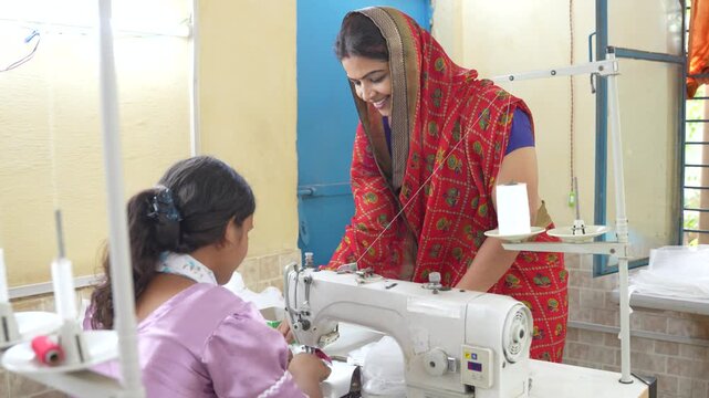 Two indian women are working on a sewing machine, creating garments in a fashion workshop, focusing on skill development and female empowerment. India
