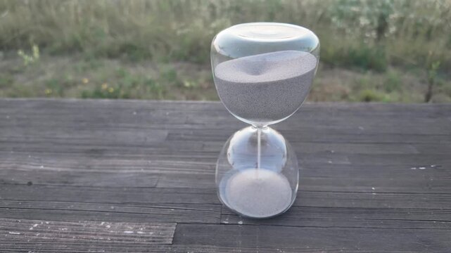 Hourglass timer with sand flowing, symbolizing passage of time and moments