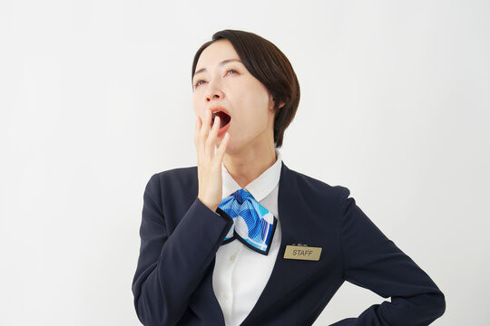 ミドル女性スタッフ　あくび　白背景