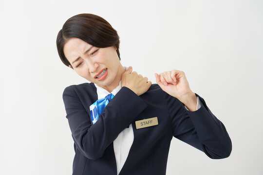 ミドル女性スタッフ　肩こり　白背景