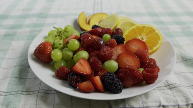 Various, delicious fruits filling plate on kitchen counter - medium, tracking shot