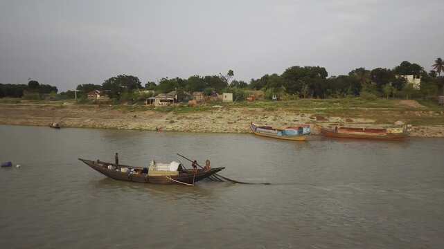 KUSHTIA, BANGLADESH &ndash; JUNE 27, 2026: Cinematic drone tracking shot following a traditional fishing boat navigating the Gorai River. The footage highlights local fishermen and inland waterways.