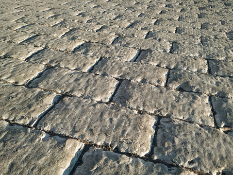 Light grey concrete covering with patterns reminiscent of ancient stonework with bricks. Covering the covering (floor) with cement decorative screed. Top view.