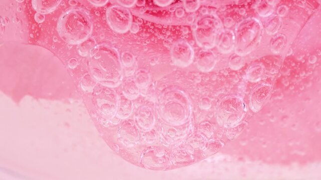 Pink serum gel background, cream, shampoo, macro soap bubbles, foam texture