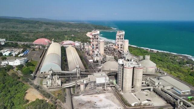 Cement plant near a tropical beach, symbolizing industrial expansion, construction progress, and economic opportunity.