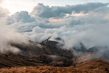 Fototapeta premium Ultra-high-resolution panoramic landscape of Mount Rinjani National Park featuring the volcanic crater lake Segara Anak, dramatic mountain ridges, clouds, and blue sky in Lombok, Indonesia.