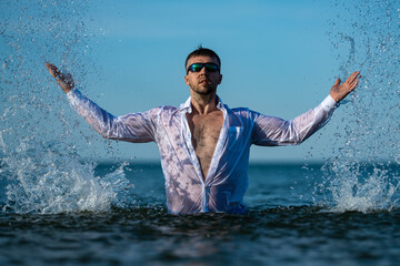 Fototapeta premium Freedom concept shown in seaside scene. Freedom feeling with raised arms. Freedom lifestyle near ocean water. Freedom reflects summer vacation mood.