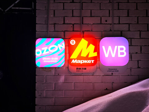 Kirov, Russia - March 04, 2026: Marketplace Ozon online store sign showing business hours and logo of competing brands in a retail space