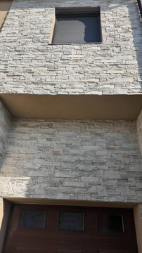 Modern house exterior featuring stone facade and wooden garage doors