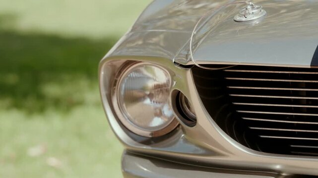 Close up of classic car round headlight chrome grille and hood ornament