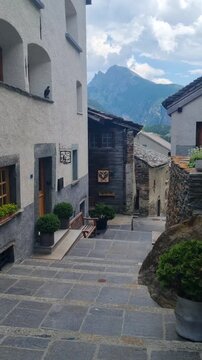 Historic village lane in Simplon Dorf, Switzerland, featuring rustic stone buildings, narrow cobblestones, and the unique alpine character of a traditional Swiss mountain settlement