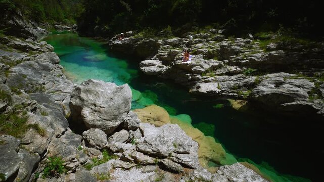 Natural swimming pool with massive white boulders and vacation tourists relaxing at Pozze Smeraldine