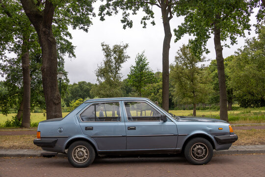 a retro 1985 volvo 360 sedan parked near park land