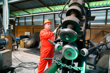 Fototapeta premium Asian technician maintaining industrial machinery in factory plant