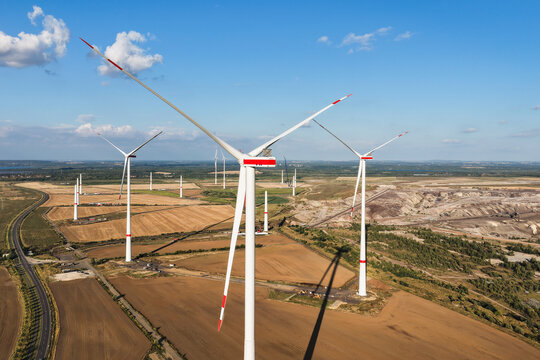 Aerial view of wind turbines standing in agricultural fields near the Schleenhain lignite open cast mine under a clear blue sky Zwenkau, Saxony, Germany.